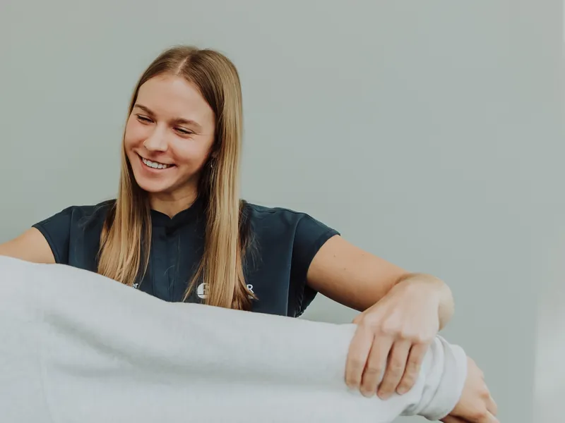 A therapist supporting a patient's elbow and wrist during a stretch