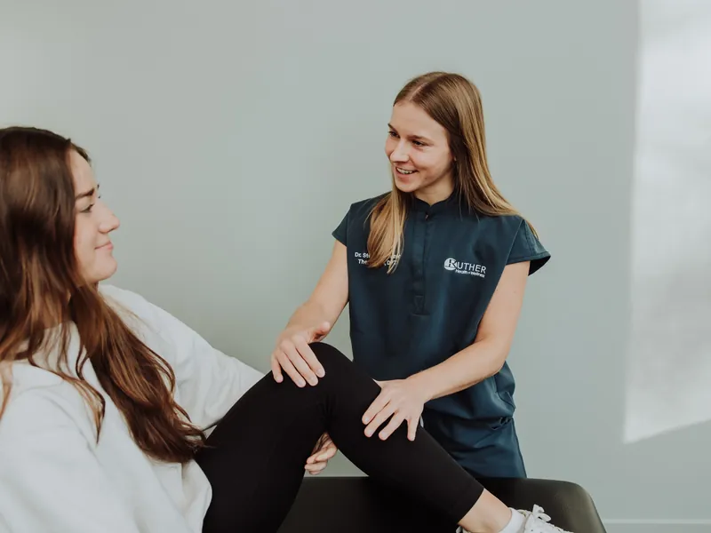 A therapist assessing a patient's knee