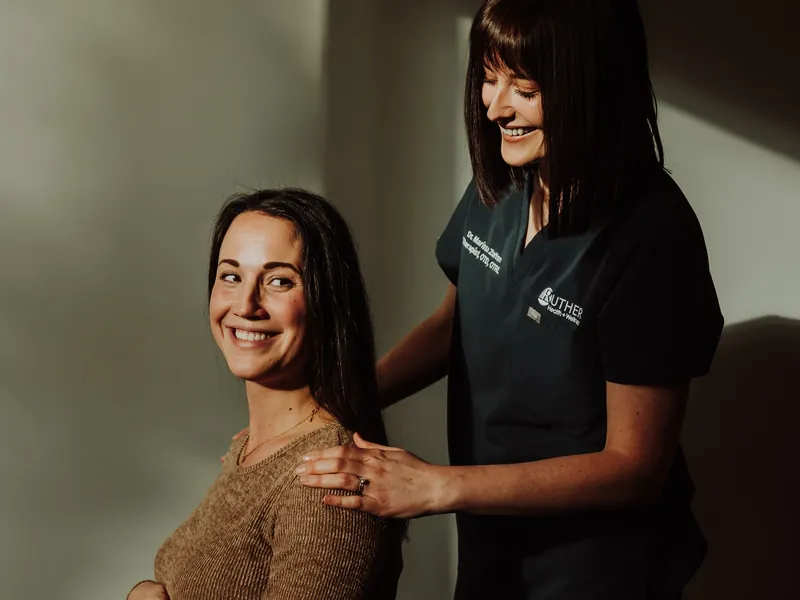 A therapist working with a pregnant patient on posture and support