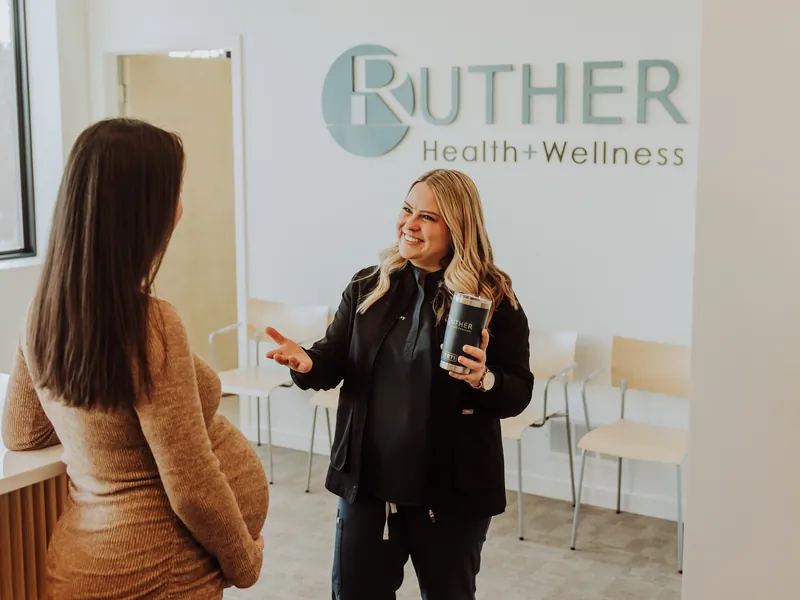A therapist talking with a pregnant patient in the clinic